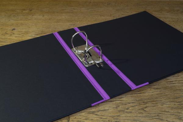 black folder open with lever mechanism and reinforced linen edges, lilac